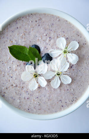 Farina di avena porridge realizzato di avena, purea di banana, latte di mandorla e frutti di bosco, tutti mescolati insieme, isolato su sfondo bianco Foto Stock