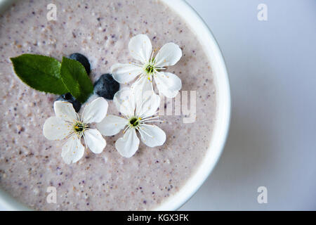 Farina di avena porridge realizzato di avena, purea di banana, latte di mandorla e frutti di bosco, tutti mescolati insieme, isolato su sfondo bianco Foto Stock