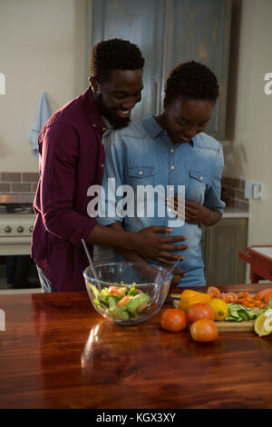 Uomo di toccare womans pancia in gravidanza in cucina a casa Foto Stock