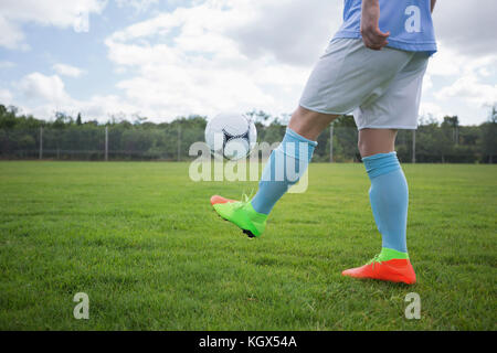 Giocatore di football juggling pallone da calcio nel terreno Foto Stock