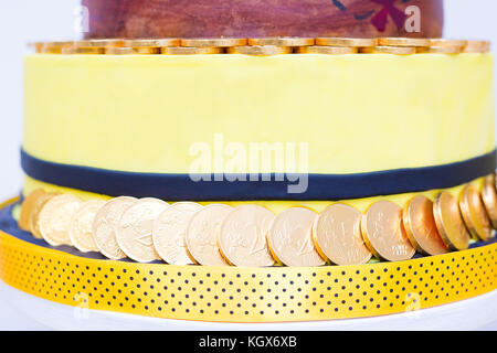 Close up di giallo torta di compleanno con le monete di cioccolato Foto Stock