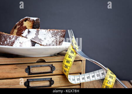 Piastra di bundt torte posto su una scatola di legno con forcella e nastro di misurazione Foto Stock