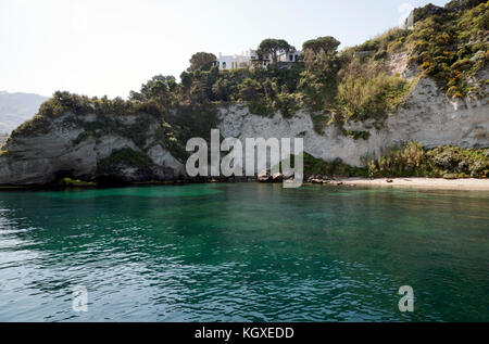 Isola d Ischia, Italia. Spiaggia nelle vicinanze di Lacco Ameno con una bellissima villa nella parte superiore del capo girato dal mare Foto Stock