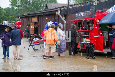 Festival goers coda sotto la pioggia per il furgone caffè Foto Stock