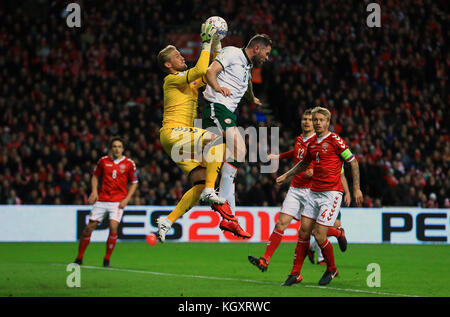 Il portiere danese Kasper Schmeichel rivendica il pallone sotto la pressione dell'irlandese Daryl Murphy durante la partita di andata e ritorno per le qualificazioni alla Coppa del mondo FIFA al Parken Stadium di Copenaghen. Foto Stock