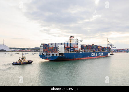 Le barche di rimorchiatore manovrano una nave container chiamata CMA CGM Rabelais nel porto di Southampton. La nave è di proprietà di Danaos Shipping. Foto Stock