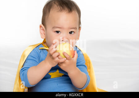 Asian toddler eating apple Foto Stock