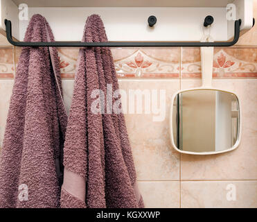 Una parete bianca del bagno con ganci per asciugamani Foto stock