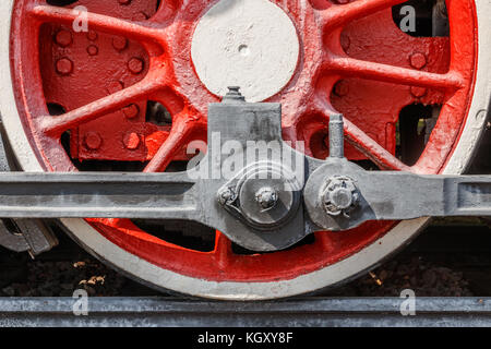 La cornice rossa e la ruota di una locomotiva a vapore con manovelle, le aste e gli assali. Foto Stock