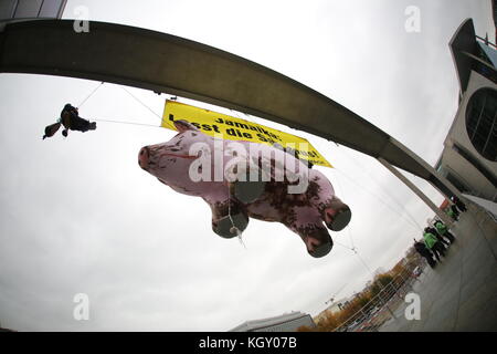 Berlino, Germania. 10 Nov 2017. Quattro attivisti si sono alleati per protestare contro la coalizione giamaicana da un ponte sul Bundestag sopra lo Sprea. Gli attivisti hanno trasportato un maiale oversize e un banner con l'iscrizione: 'Giamaica, lasciare il maiale fuori!'. Credit: Simone Kuhlmey/Pacific Press/Alamy Live News Foto Stock