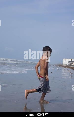 Brown ragazzo giocando sulla spiaggia Foto Stock