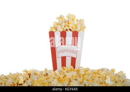 Uno rosso e bianco spogliato sacchetto etichettato popcorn riempita con burro fresco popcorn con lo stesso debordi disperse nella parte anteriore della sacca isolata su una w Foto Stock