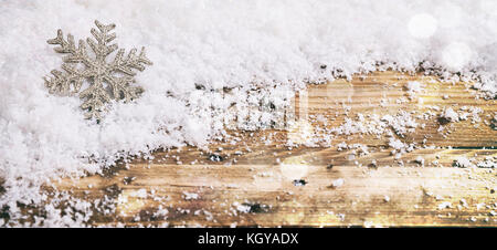 Natale il simbolo del fiocco di neve su una tavola di legno, innevate sullo sfondo bokeh di fondo Foto Stock