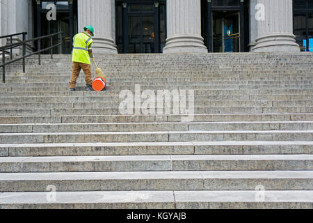 Un anonimo lavoratore comunale pulisce le fasi del James A. Farley post office su otto Avenue a Manhattan, New York City. Foto Stock