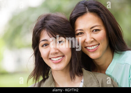 Asian madre ridendo huging e sua figlia. Foto Stock