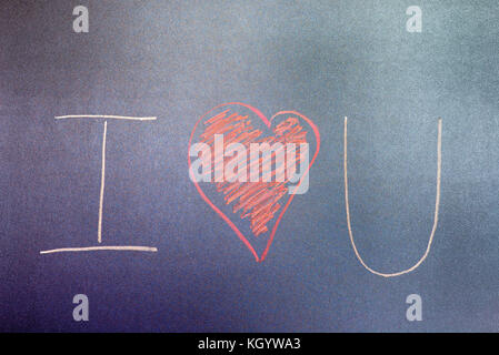 Forma di cuore e di lettere su una lavagna sfondo. Foto Stock
