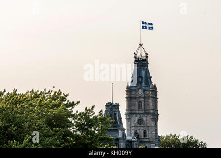 Città di Québec in Canada il bianco e blu sventola con orgoglio sulla parte superiore dell'imponente torre dell orologio del palazzo del parlamento dell'assemblea nazionale Foto Stock