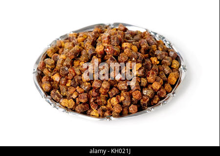 Granuli di propoli all'interno della piastra sullo sfondo, prodotto delle api Foto Stock