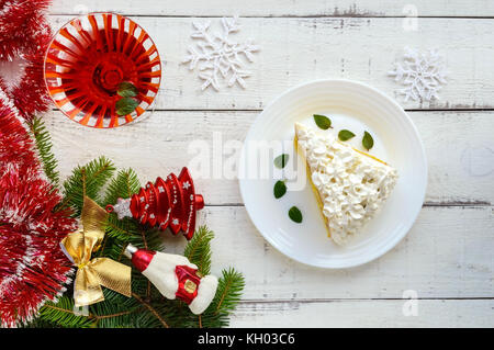 Un grande pezzo di spugna delicata decorazione delle torte di crema di aria. vetro con un cocktail. festive dessert su uno sfondo bianco. per celebrare il Natale, nuovo Foto Stock