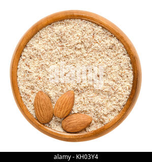 Sgusciate e massa i dadi di mandorle in ciotola di legno. commestibile, essiccato, marrone semi di Prunus dulcis. ingrediente in marzapane, torrone, i cookie. Foto Stock