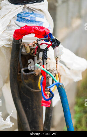 Esposta a casaccio cavi elettrici presentano un potenziale pericolo per persone, Kenya, Africa orientale Foto Stock