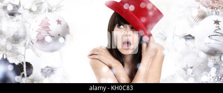 Meravigliosa donna sorpreso su sfondo di Natale con le sfere e le luci sfocate Foto Stock