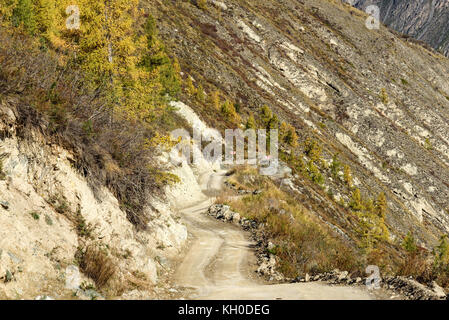 La pittoresca vista sull'avvolgimento ripida strada di ghiaia attraverso il pass, parte della serpentina di montagna, passando il pendio della montagna Foto Stock