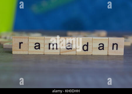 Il ramadan parola su cubi di legno sul tavolo contro sfondo blu Foto Stock
