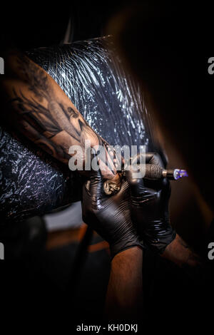 Mani di artista professionale rendendo tatuaggio in salone, vista ravvicinata Foto Stock