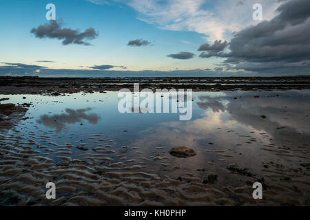 Ravensheugh Sands, East Lothian costa, Scozia, Regno Unito, 11 novembre 2017. Bassa prospettiva sul litorale, con le nuvole e pallido autunno luce con sfumature rosa riflette in piscine al tramonto con la bassa marea Foto Stock