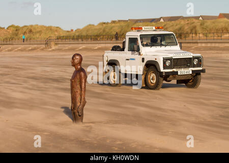 2013 bianco Land Rover SWB pick-up 4x4 bagnino fuoristrada spiaggia e pattuglia percorso veicolo di salvataggio a Crosby, Merseyside. Questa zona conosciuta localmente come "un altro luogo, sull'estuario di Mersey è famosa per le statue "Iron Men" di Antony Gormly. Forti venti settentrionali soffiano la sabbia leggera dando un effetto etereo al faggio sabbioso. Foto Stock