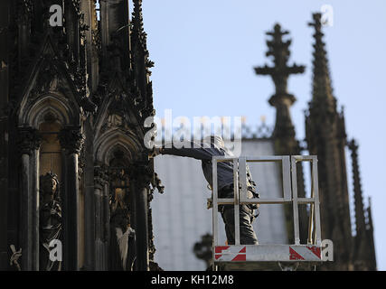 Colonia, Germania. 13 novembre 2017. Un operaio del laboratorio della cattedrale che controlla la fermezza di figure e ornamenti bloccati sulla facciata della cattedrale di Colonia, Germania, 13 novembre 2017. Crediti: Oliver Berg/dpa/Alamy Live News Foto Stock