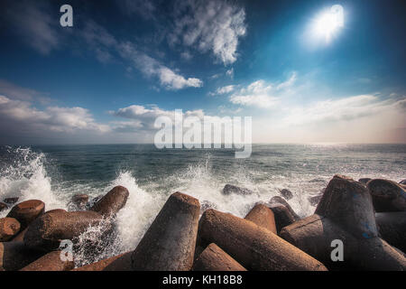 Mare di onde che si infrangono sulle rocce con schizzi Foto Stock