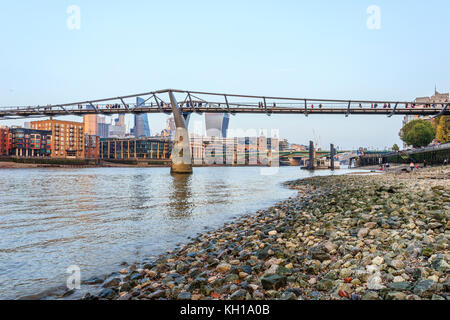 Il Millennium Bridge, Londra, Regno Unito, visto dal Tamigi foreshore a Bankside, con la bassa marea su una sera d'autunno Foto Stock