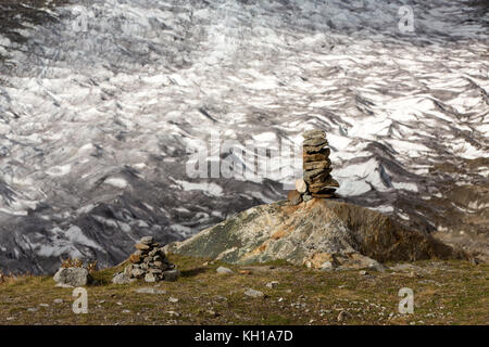 Cairns o rock-stacking di fronte il più lungo ghiacciaio d'Europa, il grande ghiacciaio di Aletsch in Svizzera Foto Stock