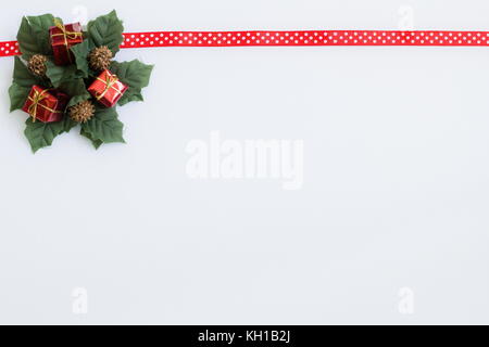 Un nastro rosso con decorazione di Natale su sfondo bianco Foto Stock