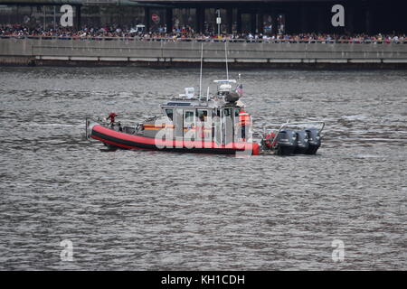 FDNY barca in pattuglia durante le celebrazioni del 4 luglio sul fiume Est, con gli spettatori che fiancheggiano FDR drive, preso da Roosevelt Island Foto Stock