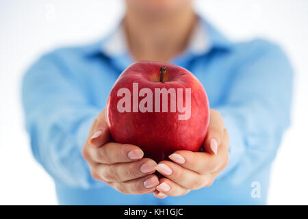 Concetto di mangiare sano in ufficio. Business donna azienda big red apple nelle sue mani, studio shot. Foto Stock