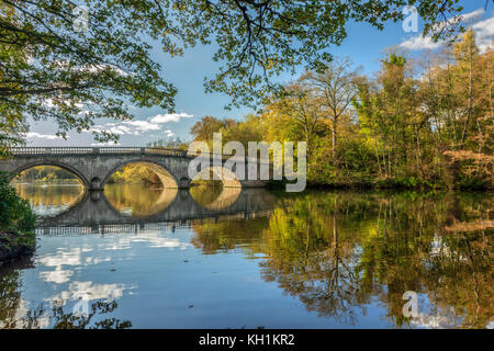 Arcuata di ponte stradale sull'acqua in autunno Foto Stock