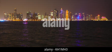 Doha, Qatar - 11 novembre 2017: vista notturna della città delle torri durante la crisi diplomatica con enorme foto del emiro su alcuni. Foto Stock