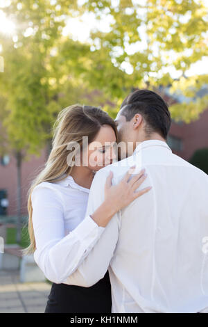 Giovane donna caucasica abbracciando il fidanzato, amore in business tra i manager Foto Stock