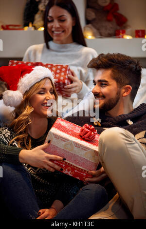 Coppia sorridente con confezioni regalo a Natale Foto Stock