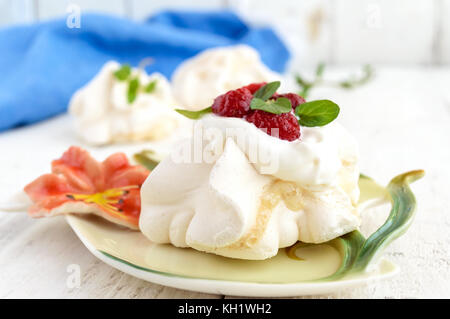 Aria Delicato dessert 'Anna Pavlova' con lamponi e panna montata su uno sfondo luminoso. close-up. Foto Stock