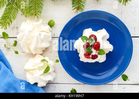 Aria Delicato dessert 'Anna Pavlova' con lamponi e panna montata su uno sfondo luminoso. La vista superiore Foto Stock