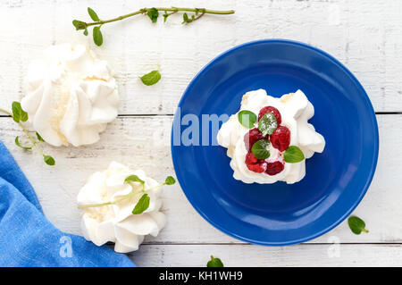 Aria Delicato dessert 'Anna Pavlova' con lamponi e panna montata su uno sfondo luminoso. La vista superiore Foto Stock