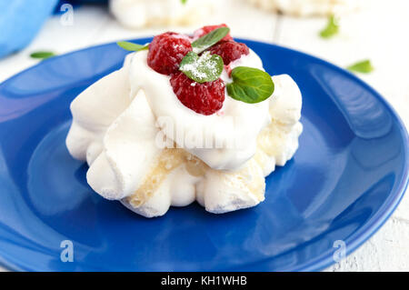 Aria Delicato dessert 'Anna Pavlova' con lamponi e panna montata su uno sfondo luminoso. close up Foto Stock