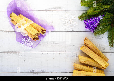 Miele home cialde fatte in forma di tubi con dado di caramello ripieno su uno sfondo luminoso. La vista superiore Foto Stock