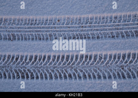 Le tracce di pneumatici per auto sulla neve da due differenti tipi di pneumatici Foto Stock