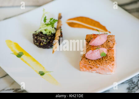 Una chiusura di un salmone confit di quinoa e piatto di insalata Foto Stock