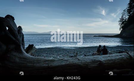 Due escursionisti preparare loro la cena sulla spiaggia a cullite cove (west coast trail, isola di Vancouver, BC, Canada) Foto Stock